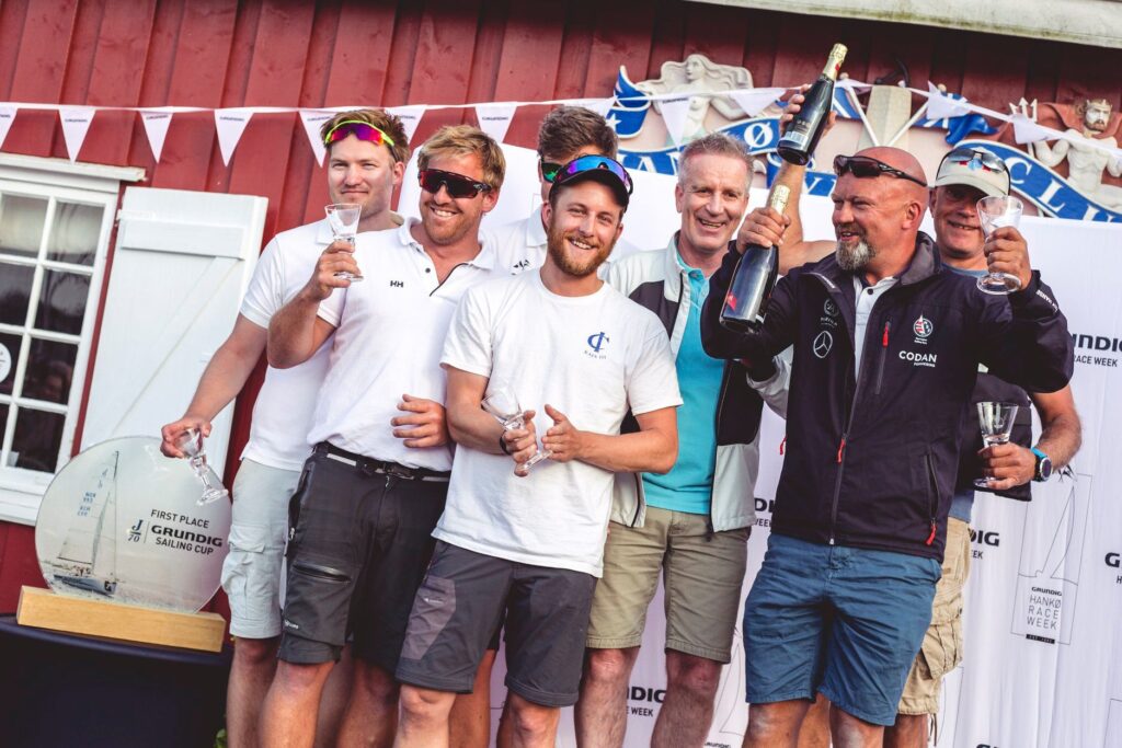 The top two crews at Hanko Race Week celebrate, Tormod Lie's team on the right and Fredrik Rygh's team on the left.